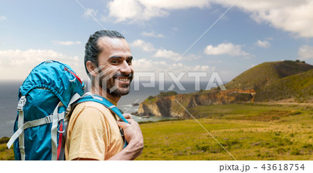 close up of man with backpack over big sur coast 43618754