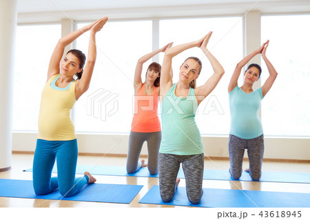 happy pregnant women exercising on mats in gym happy pregnant women exercising on mats in gym 43618945