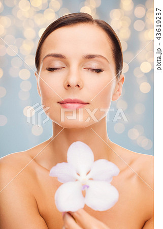 woman with orchid flower over green background woman with orchid flower over green background 43619237