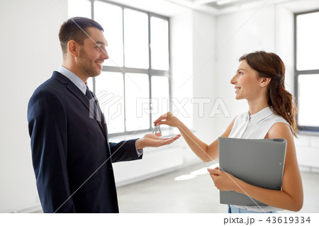 realtor giving key to customer at new office 43619334