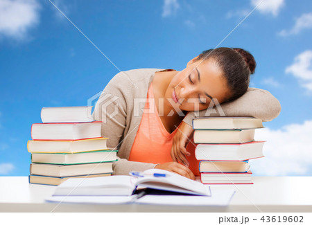 tired student girl sleeping on with pile of books tired student girl sleeping on with pile of books 43619602