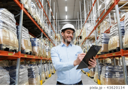 businessman in helmet with clipboard at warehouse businessman in helmet with clipboard at warehouse 43620134