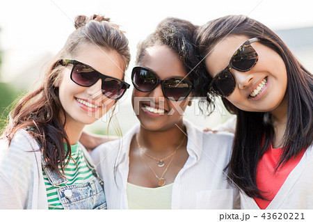happy young women in sunglasses outdoors happy young women in sunglasses outdoors 43620221
