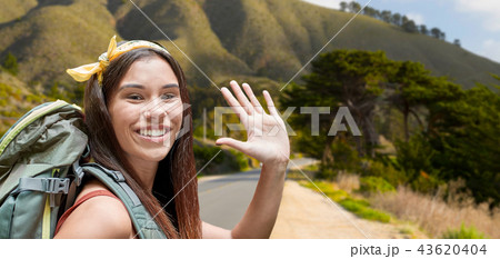 smiling woman with backpack on big sur hills 43620404