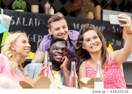 happy young friends taking selfie at food truck happy young friends taking selfie at food truck 43620526