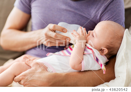 close up of father feeding baby from bottle 43620542
