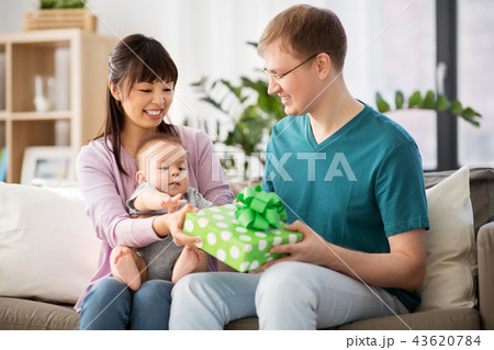 mother with baby giving birthday present to father 43620784