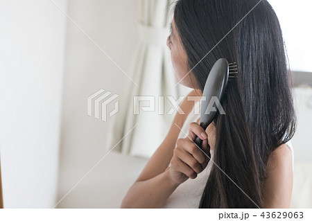 長い髪をブラシで梳かす若い日本人女性 43629063