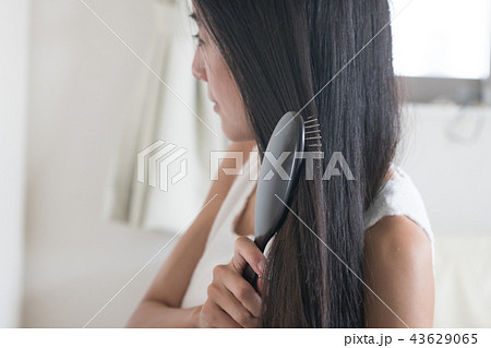 長い髪をブラシで梳かす若い日本人女性 43629065