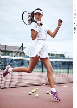 Young beautiful sexy sportswoman with tennis racket jumping on tennis court. Sports Fashion Young beautiful sexy sportswoman with tennis racket jumping on tennis court. Sports Fashion 43636068