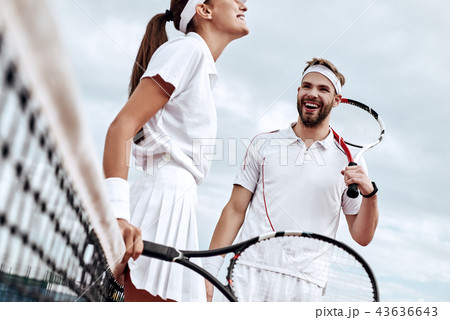 They play like a team. Beautiful young woman and man holding tennis racket and discussing set They play like a team. Beautiful young woman and man holding tennis racket and discussing set 43636643