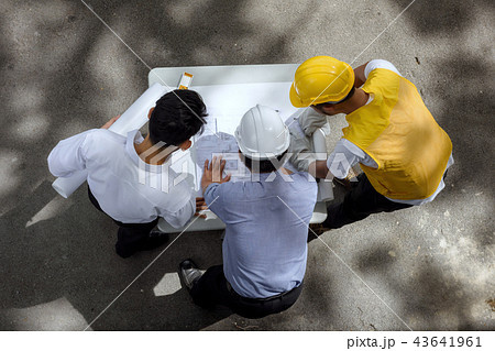 Engineer team discuss project blueprint 43641961