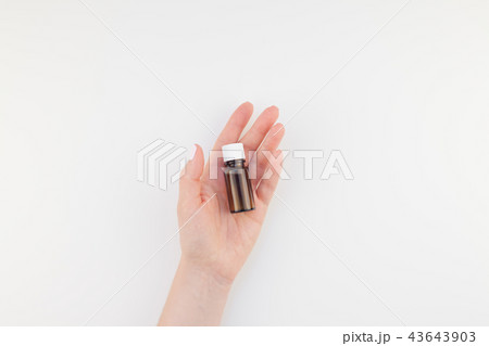 Woman hand with small glass bottle isolated 43643903