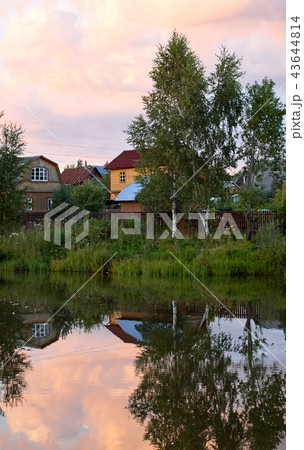 Village houses in a reflection of the lake sunset 43644814