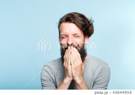 joyful excited happy man covering mouth emotion joyful excited happy man covering mouth emotion 43644959