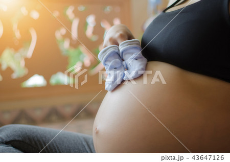 pregnant couple holding baby socks on belly pregnant couple holding baby socks on belly 43647126
