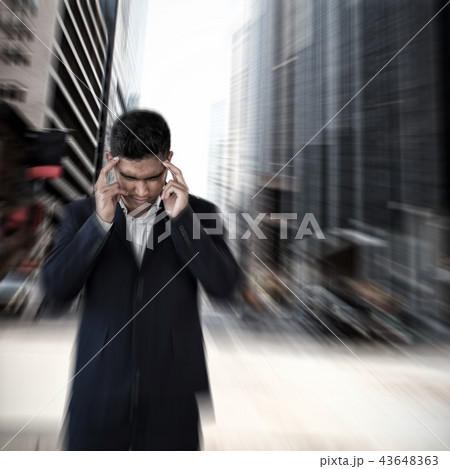 Composite image of businessman with head in hand suffering from headache 43648363