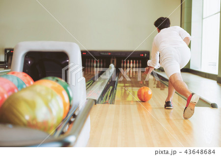 Young man playing bowling. 43648684