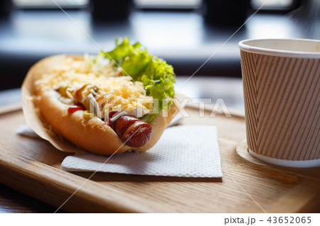 Hot dog with salad and cup of coffee on the table Hot dog with salad and cup of coffee on the table 43652065