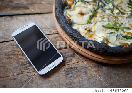 Black quattro formaggi pizza on wooden background Black quattro formaggi pizza on wooden background 43652066