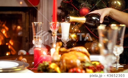 Closeup image of glasses being filled with champagne from bottle on family Christmas dinner 43652303