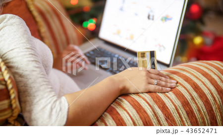 Closeup image of young woman making orders in online store for Christmas Closeup image of young woman making orders in online store for Christmas 43652471