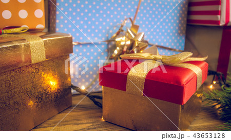 Closeup toned photo of lots of Christmas gift in colorful shiny wrapping paper and boxes Closeup toned photo of lots of Christmas gift in colorful shiny wrapping paper and boxes 43653128