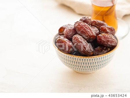 Fresh Medjool Dates in a bowl. Ramadan kareem. White background. Turkish style. Copy space. Fresh Medjool Dates in a bowl. Ramadan kareem. White background. Turkish style. Copy space. 43653424