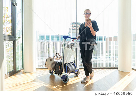 Casual woman on airport terminal talking on the cell phone, waiting for flight departure with Casual woman on airport terminal talking on the cell phone, waiting for flight departure with 43659966