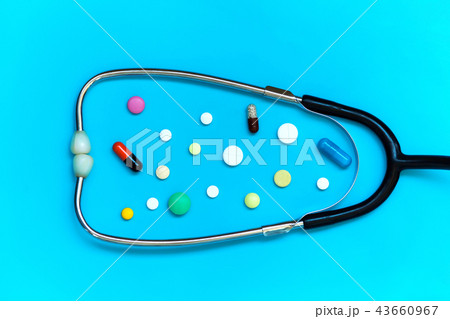 Stethoscope and different pills on blue background Stethoscope and different pills on blue background 43660967