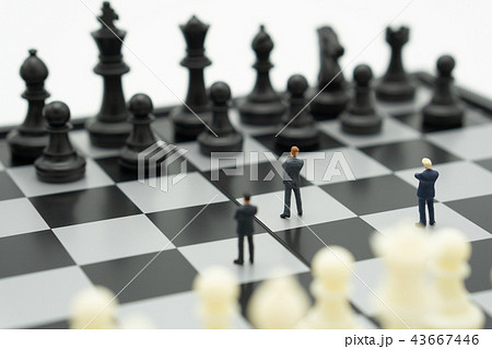 Miniature businessmen standing on a chessboard  43667446