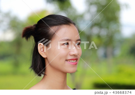 若い女性の顔、緑の背景 43668374