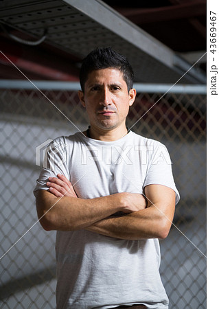 Hispanic man with arms crossed wearing casual clothing 43669467