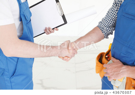 Two construction workers shaking hands 43670307