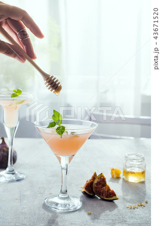 girl holds a stick for honey over  exotic cocktail 43671520