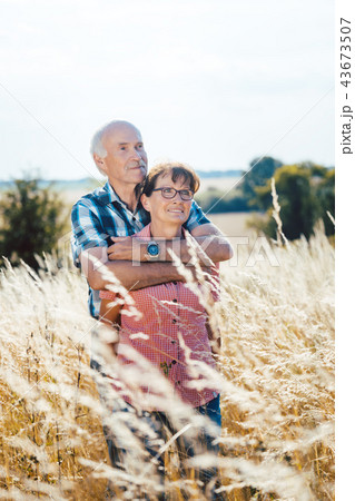 Senior man cuddling with his wife in the grass 43673507