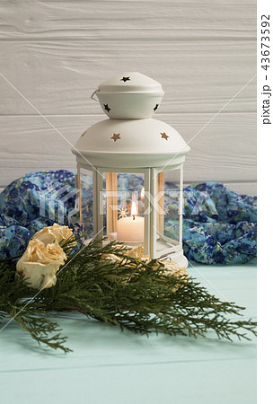 White lantern and dried roses with juniper branche White lantern and dried roses with juniper branche 43673592