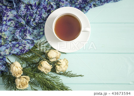 Cup of tea with dried roses and branches of junipe 43673594