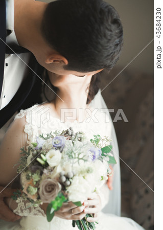 Bride holding big and beautiful wedding bouquet with flowers 43684230