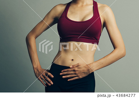 腹部を押さえるアスリートの若い日本人女性の写真素材