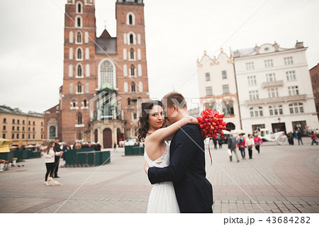 Elegant beautiful wedding couple walking on the main square in Krakow 43684282
