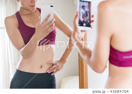 スマホで自撮りをするダイエット中の若い女性 43684704