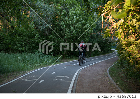 Photo of bicycle road with bicyclist among trees Photo of bicycle road with bicyclist among trees 43687013