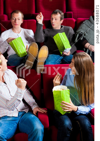 People eating popcorn in theatre 43688071