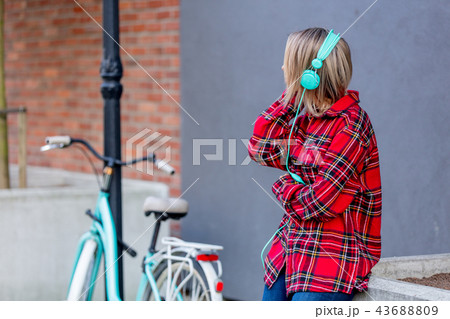 Young blond girl with headphones and bicycle 43688809