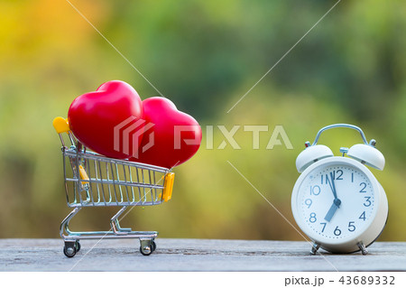 Red heart shape in shopping cart and white clock Red heart shape in shopping cart and white clock 43689332