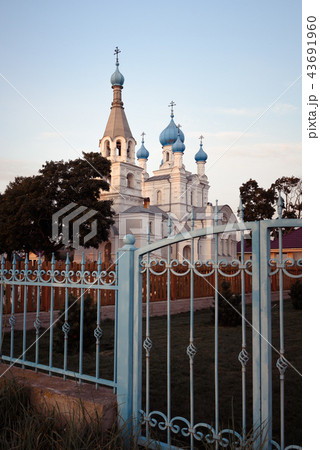 Church of Peter and Paul in the village of Vetvenik with wrought iron gates at sunset. 43691960