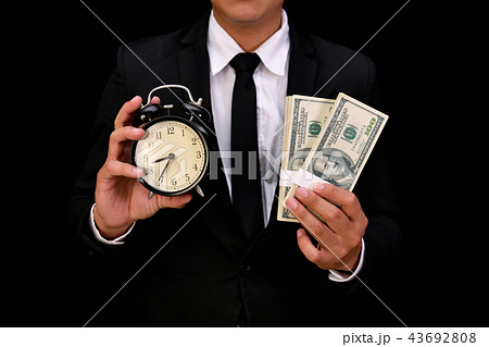 Business concept. Businessman holding a clock on a black backgro Business concept. Businessman holding a clock on a black backgro 43692808