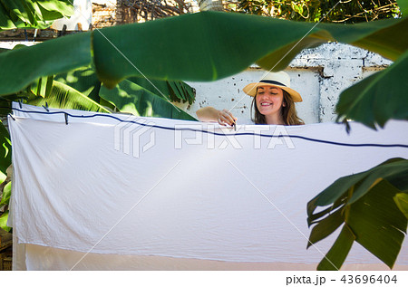Girl hanging laundry on a clothes line Girl hanging laundry on a clothes line 43696404