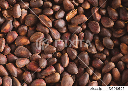 Pine nuts in shells of ciberian cedar as a background. Macro Pine nuts in shells of ciberian cedar as a background. Macro 43698695